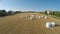 Drone flying over field counting bales of hay for report on harvested crops