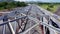 Drone flying over steel bridge during the sunny day. The movement of cars on a road bridge from a birds eye view. View