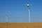 Drone flying over wheat field with wind turbine