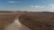 Drone following car driving fast in dusty isolated remote highlands in Iceland. Aerial view vehicle exploring icelandic