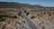 Drone following silver minivan car moving along beautiful desert hill road in summer Arizona, USA. Road trip concept.