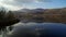 Drone footage of calm lake and mountains against sky