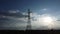 Drone footage of electric poles and wires in the sky at sunset in the countryside. Silhouette of electric pole at dusk.