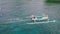 Drone footage of fisherman on a white small fishing boat sailing fast in the sea