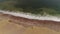 Drone footage of green waves white tide, multicolored shoreline, clay beach.