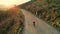 Drone footage of woman cyclist in sunset on bike