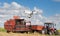 Drone in front of tractor and combine harvester in field
