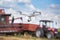 Drone in front of tractor and combine harvester in field