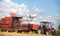 Drone in front of tractor and combine harvester in field