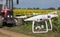 Drone in front of tractor in sunflower field