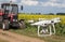 Drone in front of tractor in sunflower field