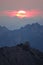 DRONE: Golden sun rises from behind the rocky mountain range on a calm morning.