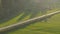 DRONE: Golden sunbeams shine on the active tourist riding bike along rural road.