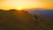 DRONE: Golden sunset illuminates the way for mountain biker pedalling uphill.