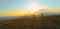 DRONE: Group of mountain bikers speeds down a grassy hill on a sunny spring day.