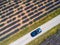 DRONE: Happy woman outstretches arms out of the sunroof during a road trip.