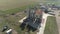 Drone from a height flies around a grain dryer on an agricultural farmstead