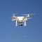 Drone hovering against blue sky on sunny day