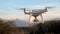 A drone hovers in flight in front of the mountains of the alps in France.