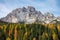 DRONE: Idyllic view of colorful woods covering the valley beneath the Alps.