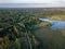 drone image. country lake surrounded by pine forest and fields f