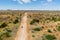 Drone image of offroad vehicle driving on dirt road in African bush