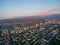 Drone Image Over City at Sunset With Mountains