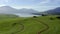 Drone, mountains and countryside with lake, landscape and outdoor growth, ecology or environment. Aerial, hill and field