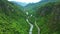 Drone, mountains and nature with road in forest for environment, countryside wildernesses and trees. Travel, river and