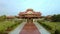 Drone Moves along Pool between Plants to Temple Red Pagoda