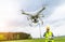 Drone operated by construction worker inspecting wind turbine