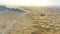 Drone over a rocky ridge among the sandy desert