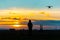 Drone over the Village at cloudy Sunset with his Pilot