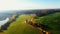 Drone panning above amazing pastoral autumn field, sunrise lake and forest at big countryside farm estate on sunny day.