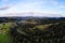 Drone panorama of spring landscape of evergreen forest and mountains with dramatic sky