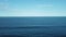 Drone passes through vegetation and arrives at the beach, showing the ocean horizon.