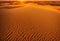 Drone perspective of golden sandy desert dunes at sunset. AI generated.