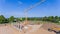 Drone photo of a large construction site on which a factory building is being erected. The foundations for the piers have been