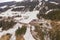 Drone photography of mountain sky slope, railway bridge going over slope, train driving over bridge and sky lifts