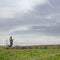 Drone pilot. Man flying drone in rural location against cloudy sky.