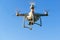 Drone quad copter with digital camera flying in blue sky