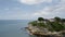 Drone quickly flies around the island with Fort James ruins, A liner is visible on the horizon