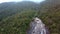 Drone Rises above Tableland with Waterfall against Misty Jungle