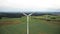 Drone rising above large windmill turbine with red blade stripes, alternative sustainable eco energy sources concept.