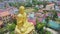 Drone Rotates above Large Buddha Monument against Cityscape