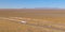 DRONE: Semi-trailer truck transports merchandise across Utah desert on sunny day