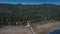Drone shoots the road from the lake deep into the dense forest, aerial view of Big Bear Solar observatory on the horizon of the mo