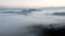 Drone shot, aerial view of Umbria, Tuscany in Italy. Sunrise with fog in early morning. Clouds in the valley.