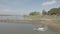 drone shot of cars with motorbikes crossing bamboo bridge over a river