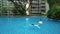 Drone shot of child swimming away from other in a beautiful swimming pool in the condominium, singapore
